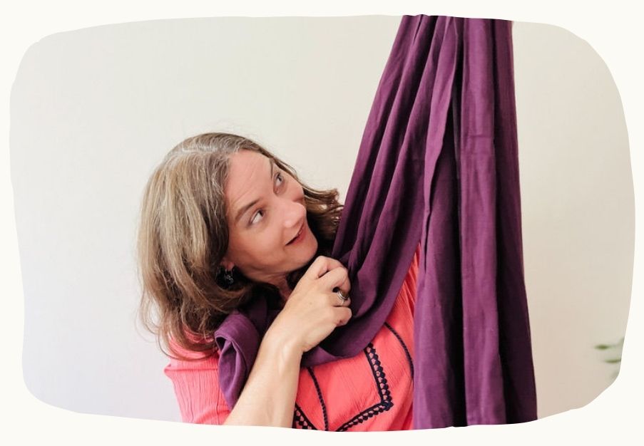 Frau probiert ein langes Tragetuch an – humorvoller Einstieg in die Welt des Tragens und der Co-Regulation